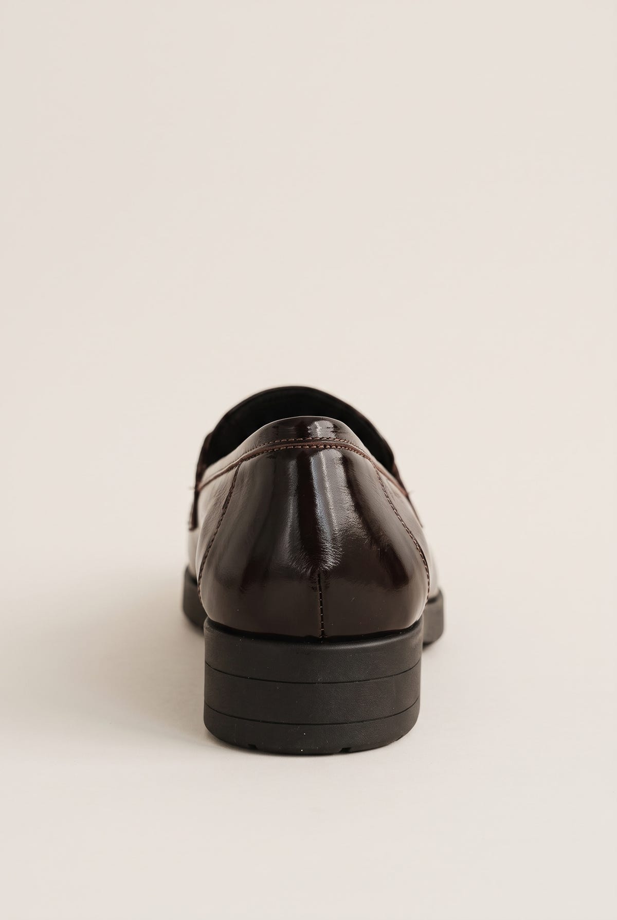 Back view of a brown patent loafer showing the smooth heel counter and low chunky dark block heel