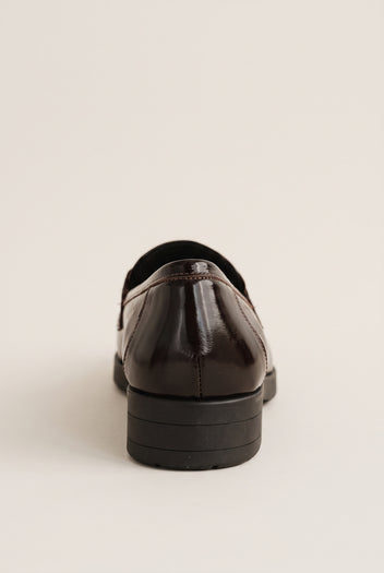 Back view of a brown patent loafer showing the smooth heel counter and low chunky dark block heel