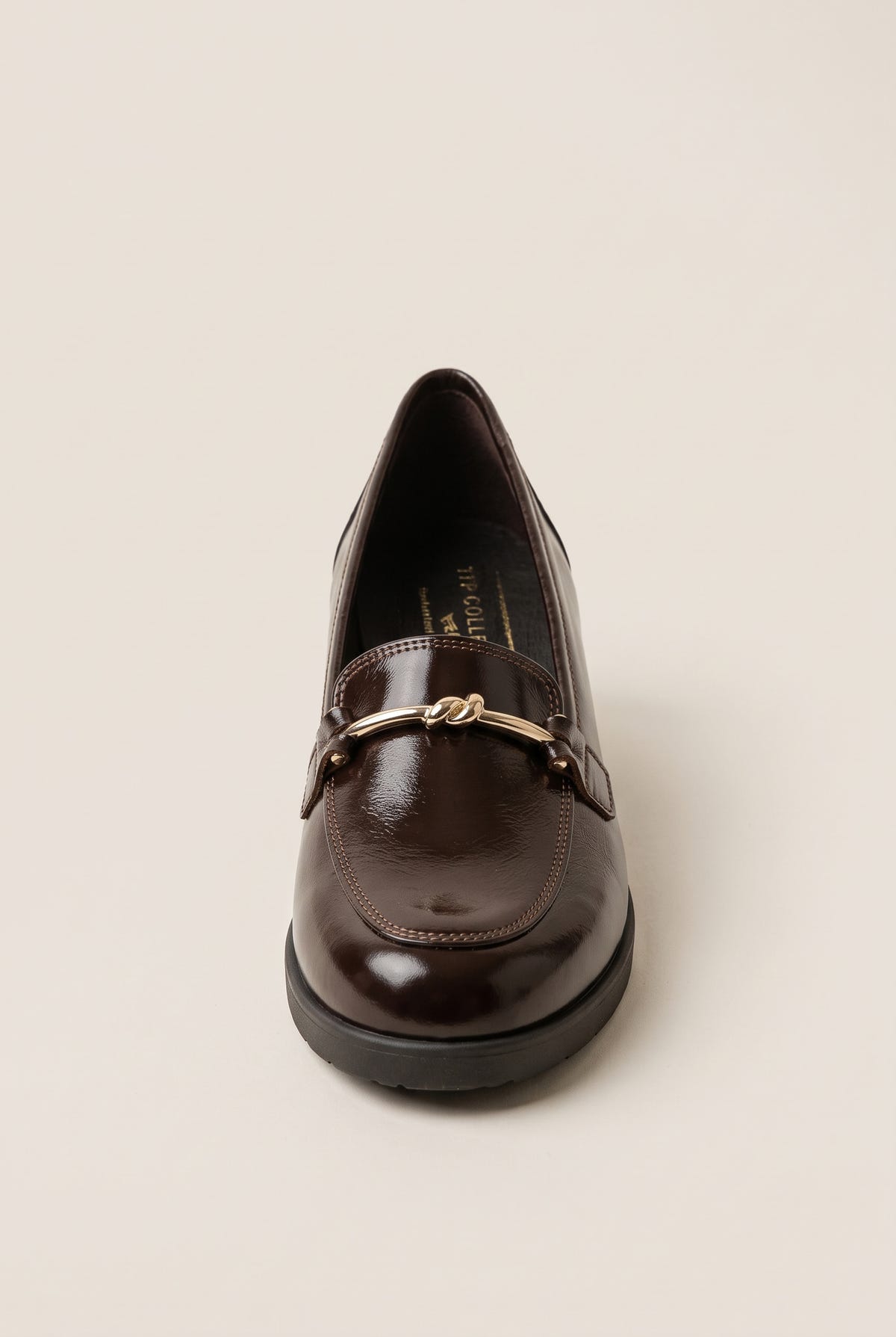 Front view of a brown patent loafer showing its rounded toe and gold horsebit trim on a low sole