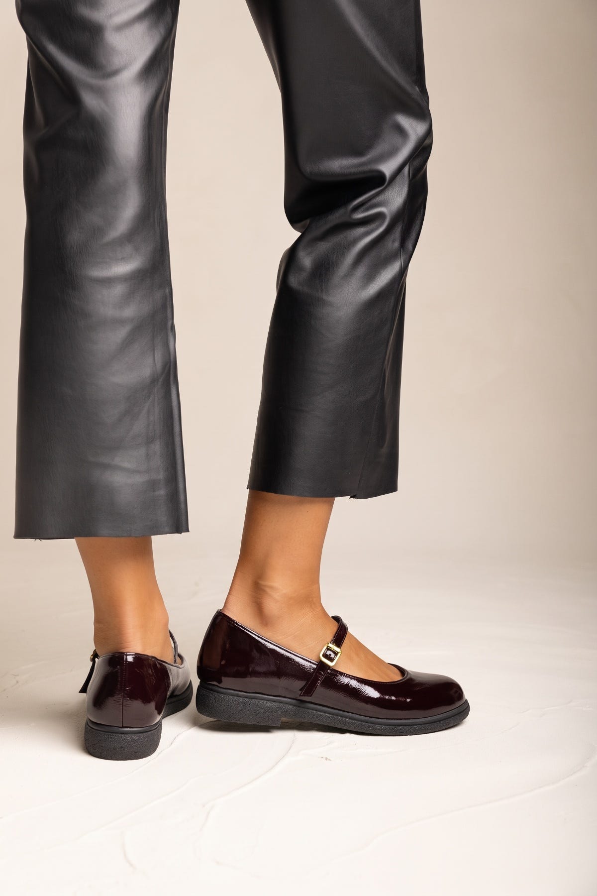 Bordeaux patent Mary Jane flats with thin ankle strap, pair worn with black leather trousers