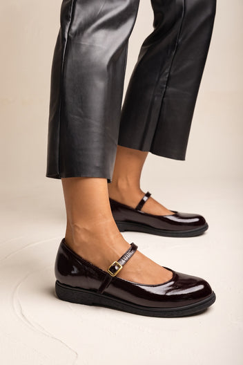 Bordeaux patent Mary Jane flat with ankle strap, worn with black leather trousers
