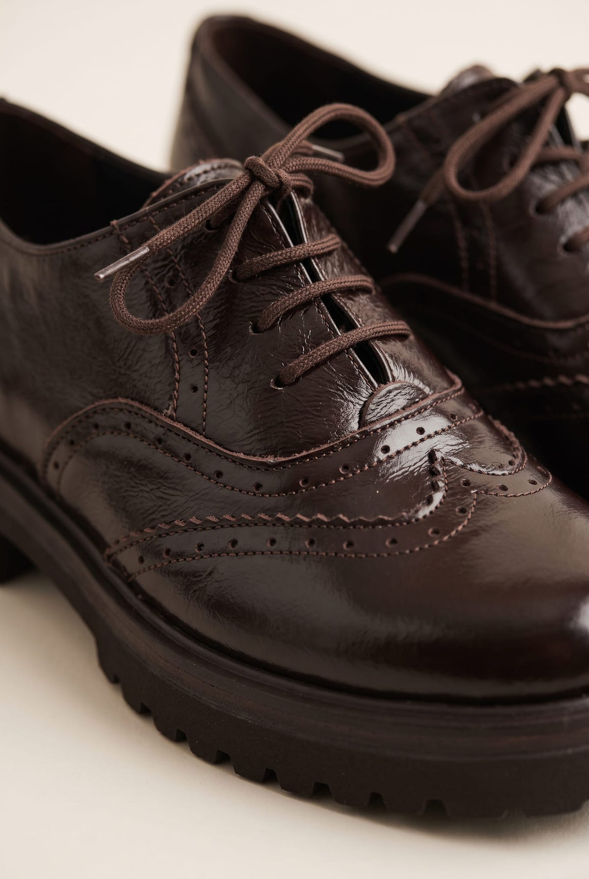 close-up of a dark brown lace up brogue with perforated wingtip pattern, brown laces and a deep lug sole