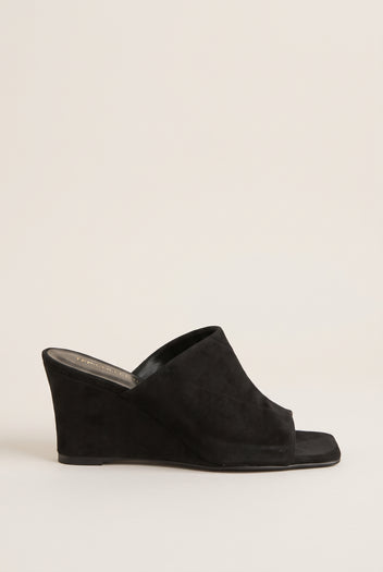 Side view of black suede wedge mule with wide vamp band, square open toe and a solid wedge heel