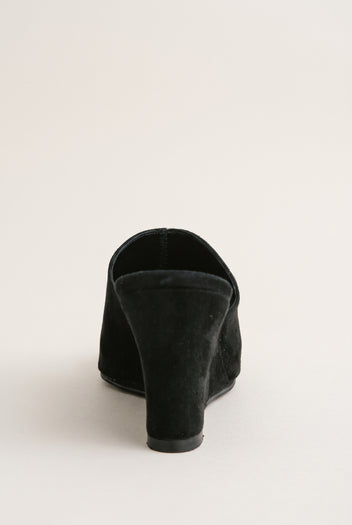 Back view of black suede wedge mule showing the solid wedge heel and wrap-over vamp