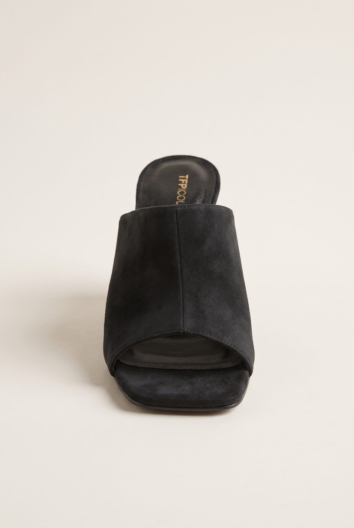 Front view of black suede mule with a wide wrap-over vamp band, square open toe and padded footbed