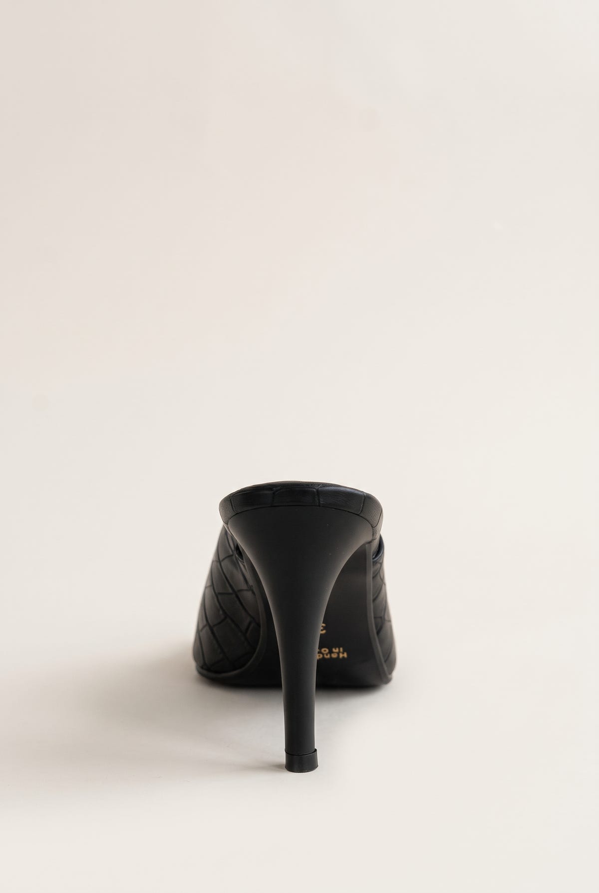 Back view of a black croc-embossed mule showing the tall slim heel and the rounded heel counter