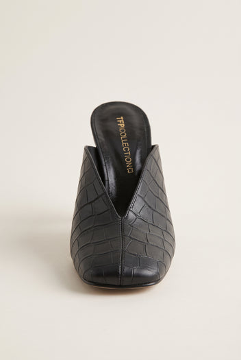 Front view of a black croc-embossed mule showing the squared toe and the deep V-shaped vamp opening