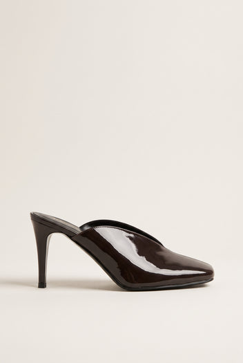 side view of one glossy dark brown patent square toe mule with a thin stiletto heel and low cut vamp