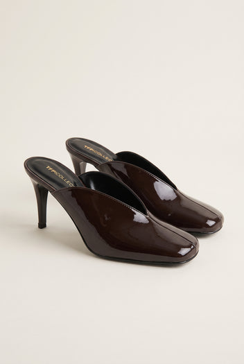 pair of glossy dark brown patent stiletto mules angled to show the square toe and slim heel