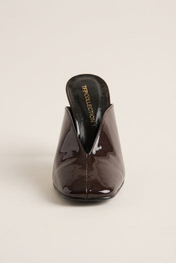 front view of one glossy dark brown patent stiletto mule showing the square toe and open V vamp