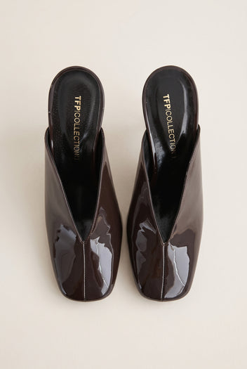 top view of a pair of glossy dark brown patent square toe mules with a deep V cut vamp