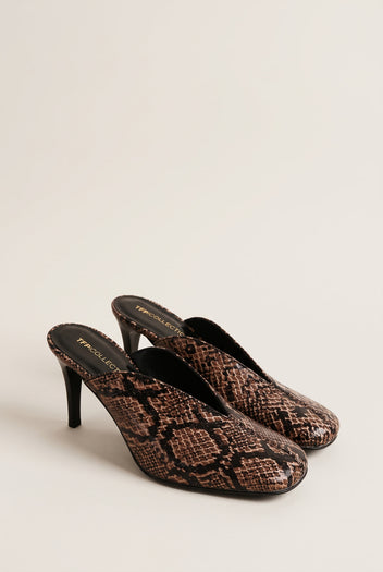 pair of brown snake print stiletto mules angled to show the square toes and slim heels