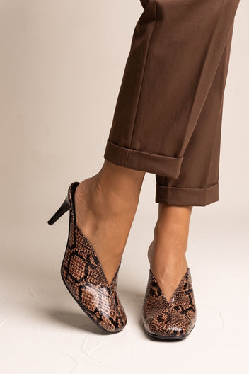 model wearing brown snake print stiletto mules with cuffed brown trousers, feet angled forward