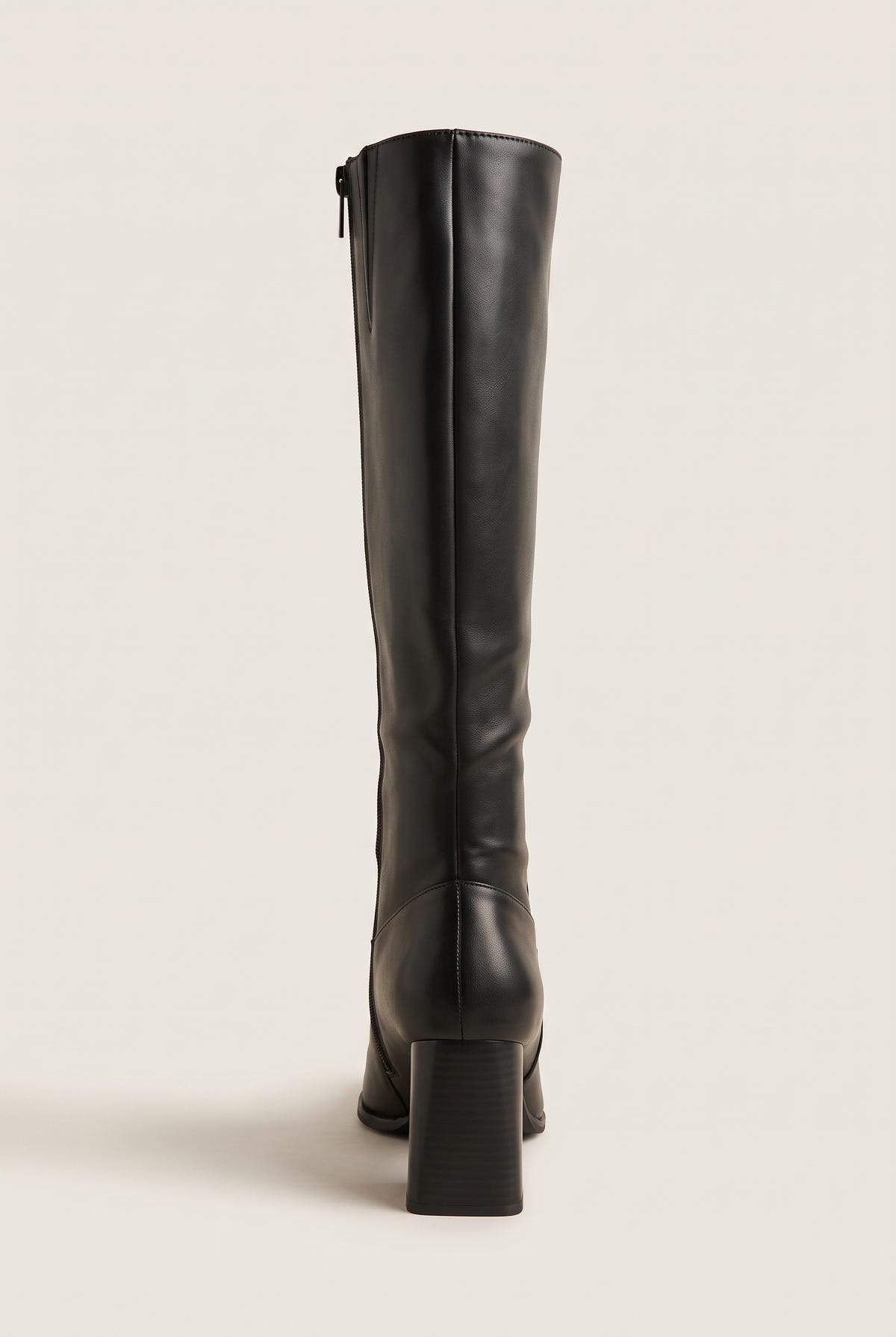 Back view of a black smooth leather knee-high boot with block heel, back seam and side zip at the top