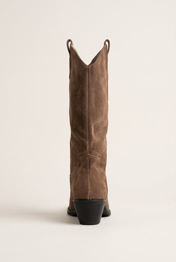 Back view of taupe suede cowboy boot with tall shaft and block heel with dark sole