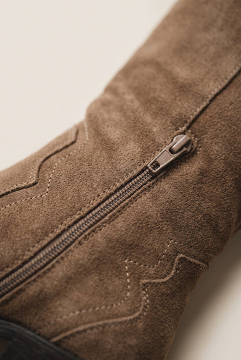 Close-up of inside zipper and decorative stitched suede upper on a taupe cowboy boot shaft