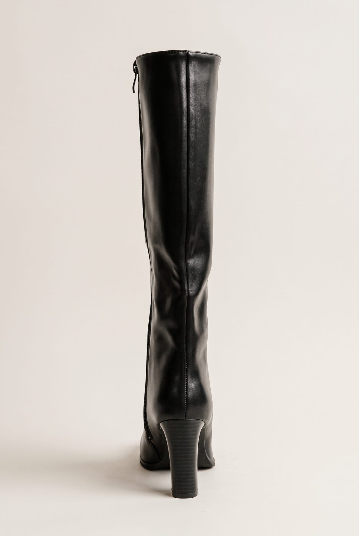 Back view of a black knee-high boot showing the center back seam, the small rear zipper pull near the top and the tapered block heel