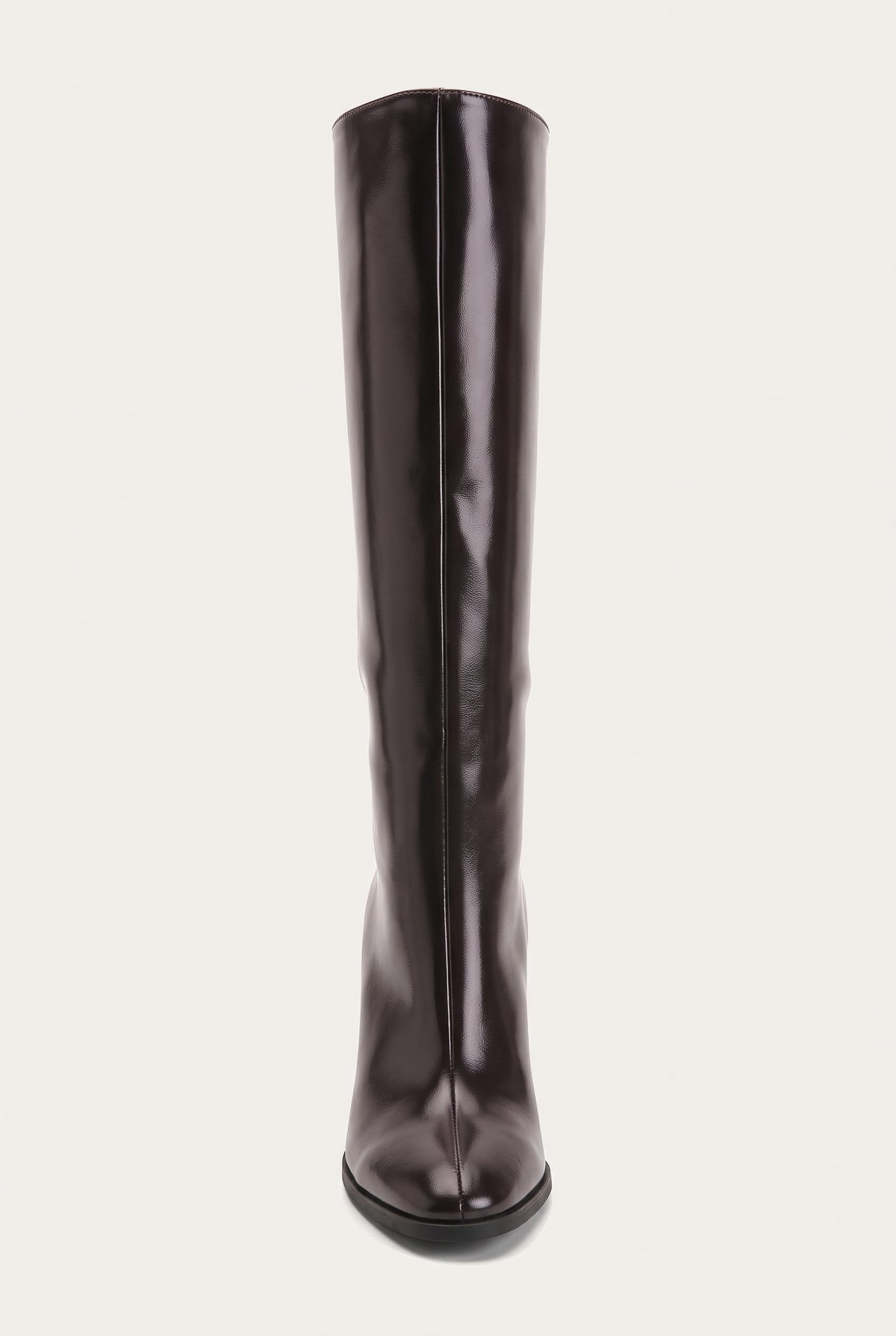 Front view of a tall dark brown boot with narrow pointed toe and smooth shaft rising straight up on a pale surface