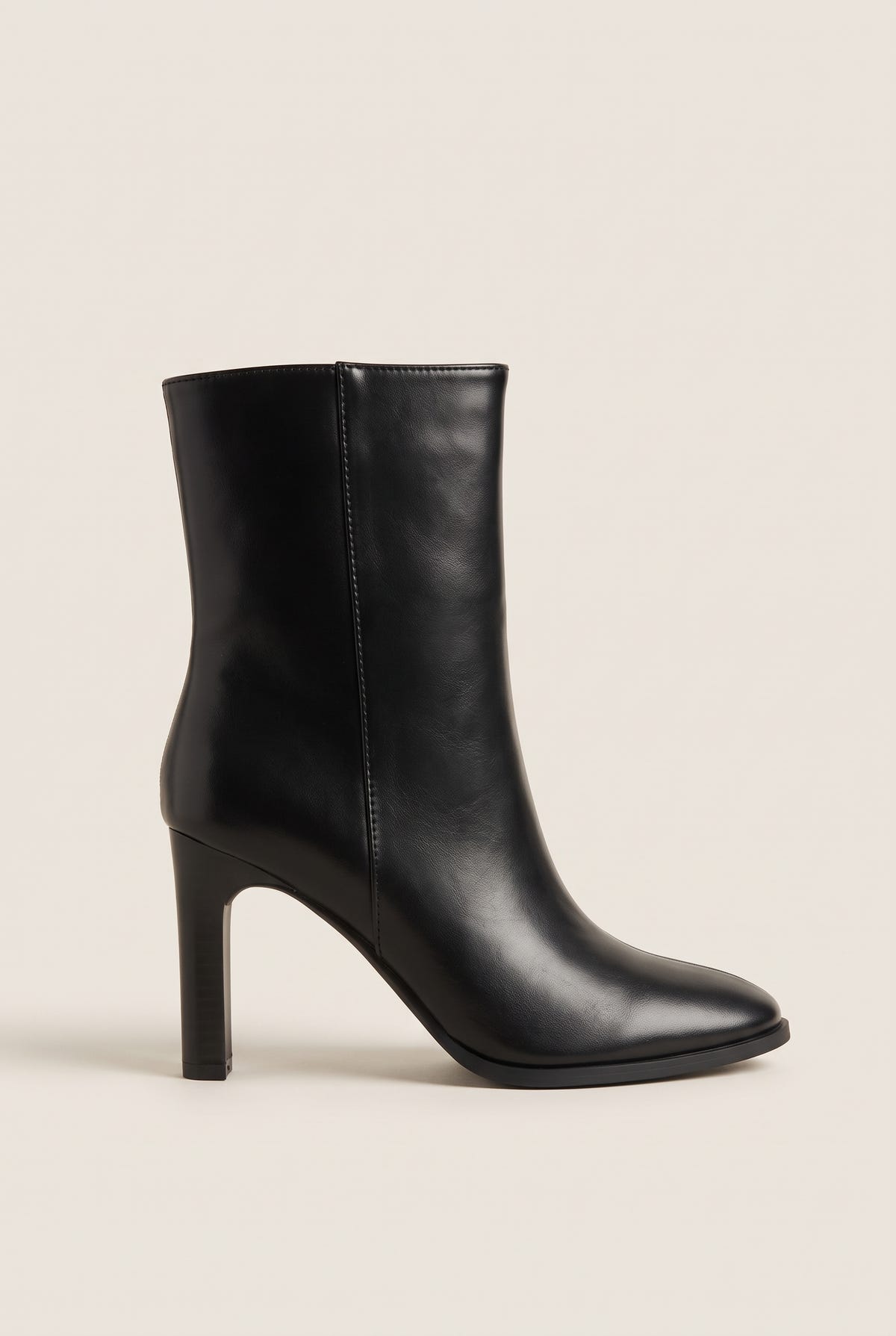 Side view of a black leather ankle boot with rounded toe and slim high block heel on white