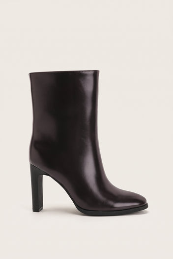 Single brown leather ankle boot in side profile showing pointed toe, low-cut shaft and tall block heel