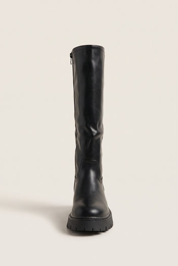 Front view of a black knee-high boot with rounded toe and thick lug sole standing upright with zip at the back