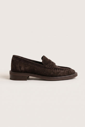 Side view of brown suede penny loafer with low heel, stitched moc toe and penny strap
