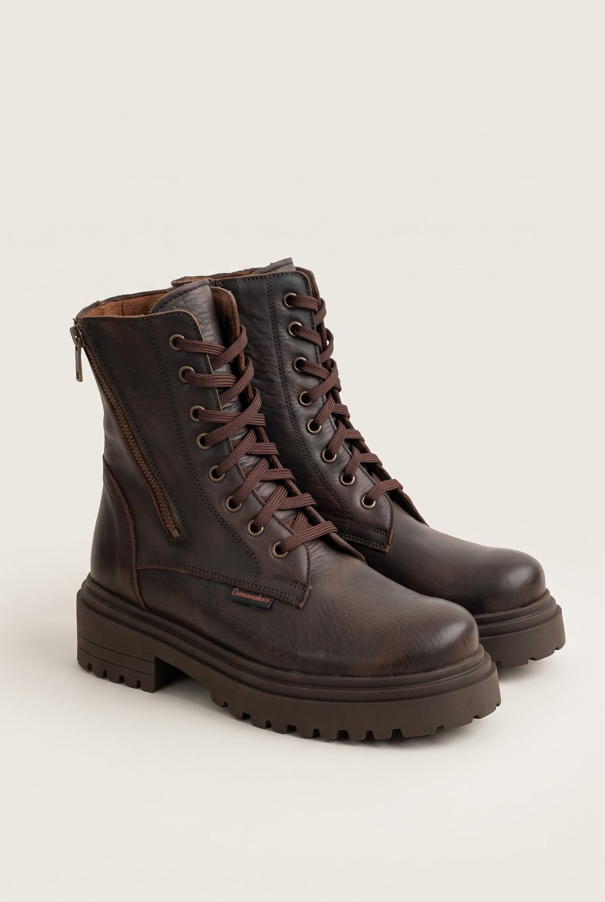Angled pair of brown matte combat boots with laces, rounded toes and rugged lug soles