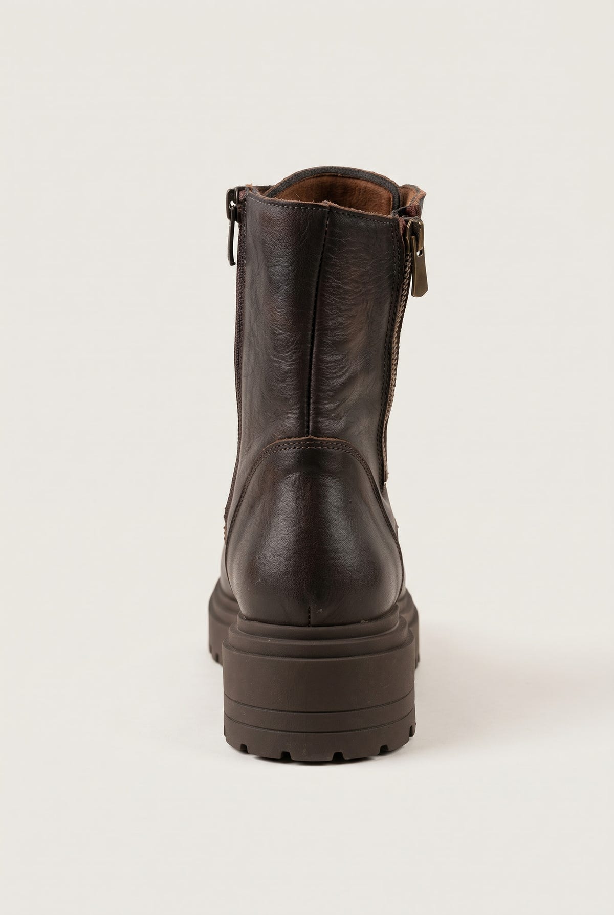 Back view of brown matte combat boot showing vertical zipper seam and chunky lugged heel