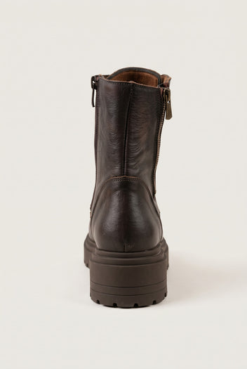 Back view of brown matte combat boot showing vertical zipper seam and chunky lugged heel