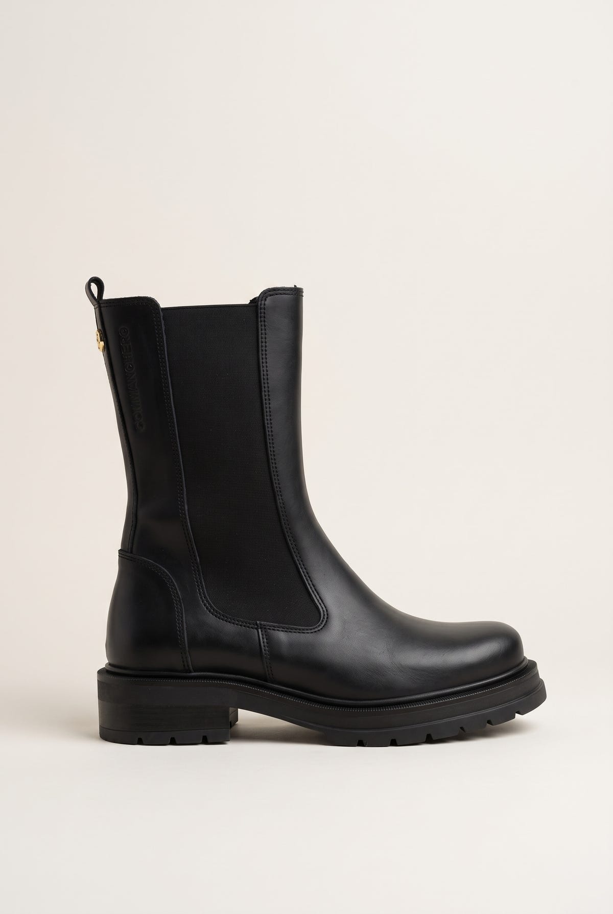 Side view of black matte leather chelsea boot with elastic side panel and low lugged sole