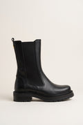 Side view of black matte leather chelsea boot with elastic side panel and low lugged sole