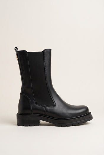 Side view of black matte leather chelsea boot with elastic side panel and low lugged sole