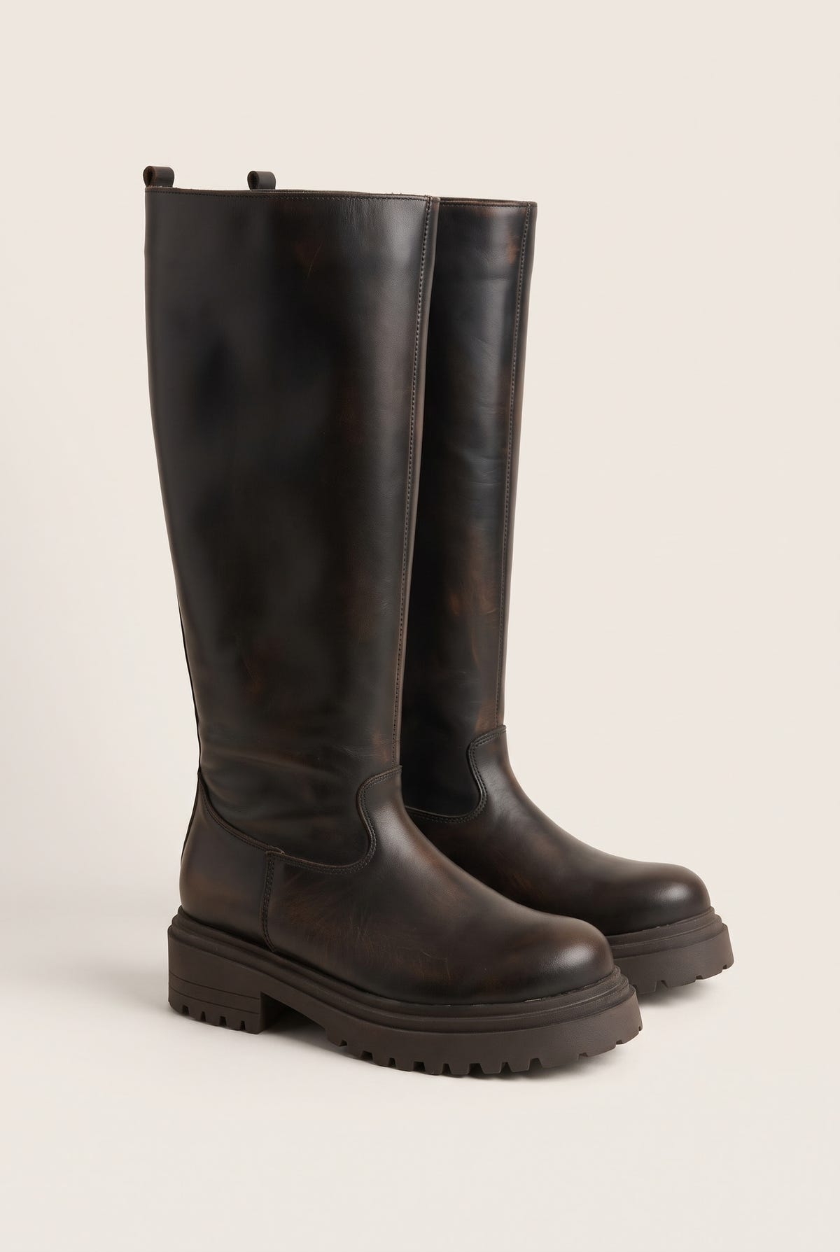 Angled pair of dark brown matte knee-high boots with chunky soles and rounded toes