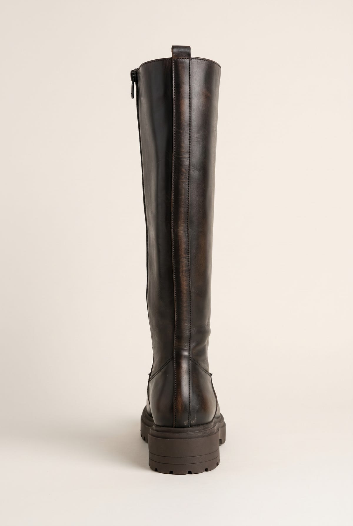 Back view of dark brown matte tall boot showing vertical zipper seam and lugged heel