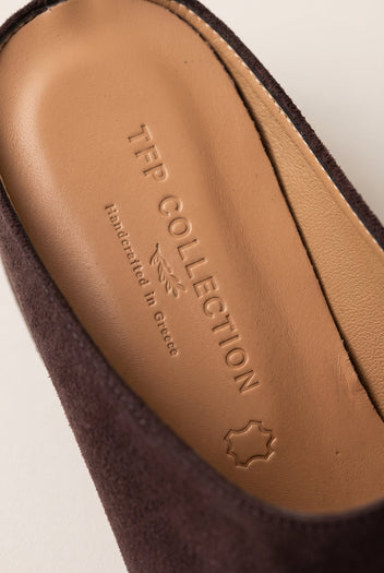 Close-up of the tan leather insole and brown suede inner edge of a pointed toe mule