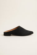 Side view of a single black suede pointed toe mule with a low flat heel and dark sole