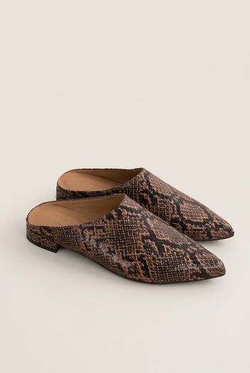 Angled view of a pair of brown snake-effect pointed toe mules with open backs and low flat heels