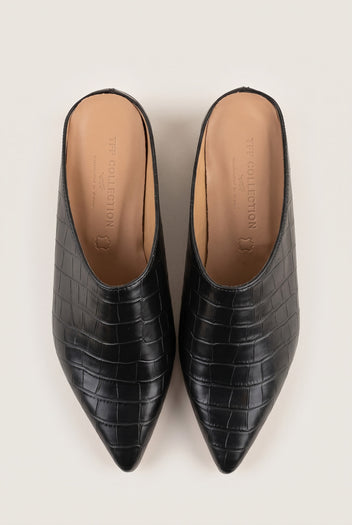 Top view of a pair of black croc-embossed pointed toe mules with tan leather insoles