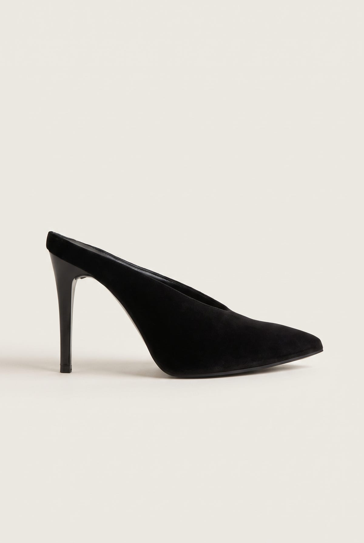 Side view of a single black velvet pointed toe mule with a tall slim stiletto heel
