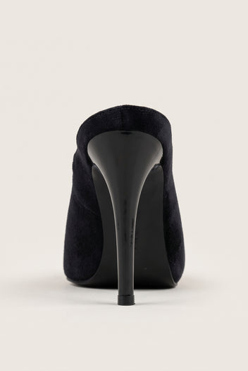 Back view of a black velvet stiletto mule showing the rounded heel counter and tall slim heel