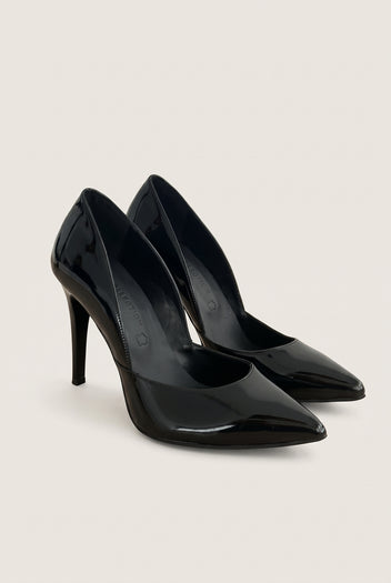 Pair of black patent pointed-toe pumps at an angle showing both cut-away sides and glossy finish on pale beige