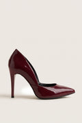 Side view of a bordeaux red patent pointed-toe pump with a cut-away side and a tall slim heel on pale beige