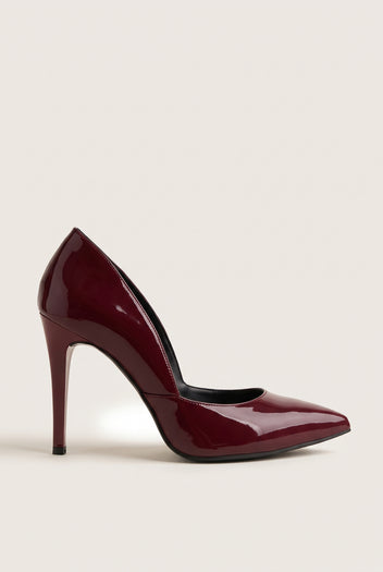 Side view of a bordeaux red patent pointed-toe pump with a cut-away side and a tall slim heel on pale beige