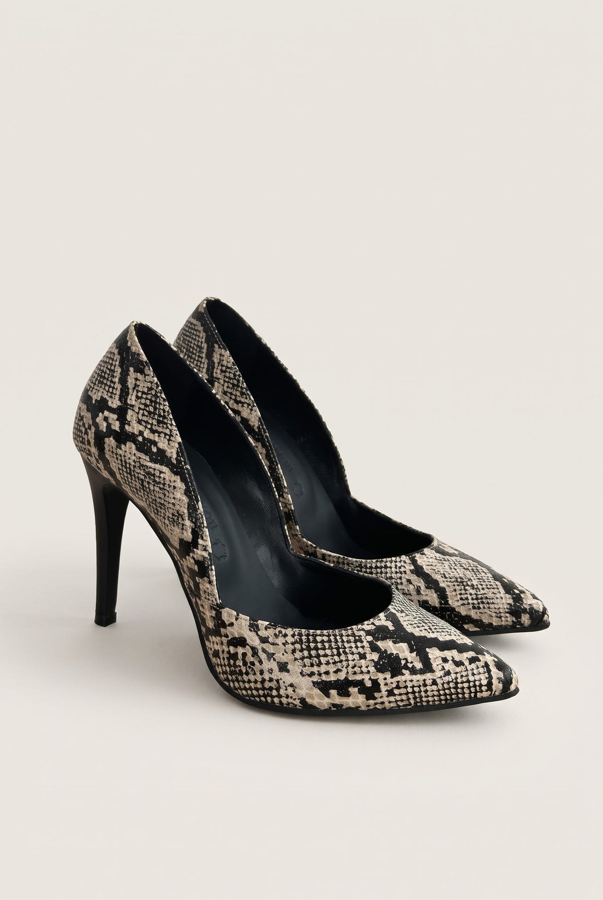 Pair of ivory and black snake-print pumps seen at an angle showing cut-away sides and pointed toes
