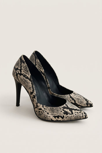 Pair of ivory and black snake-print pumps seen at an angle showing cut-away sides and pointed toes