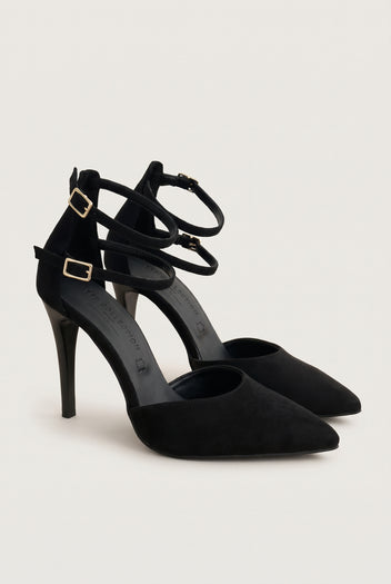 Pair of black suede pointed toe pumps with crossed ankle straps and gold buckles, front three-quarter view