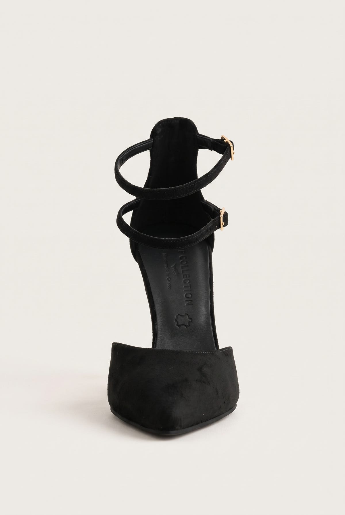 Rear view of black suede pointed pump with thin ankle straps and gold buckles above the slim stiletto heel