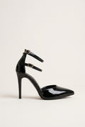 Black patent pointed toe pump with double ankle straps and thin stiletto heel in side view on a light surface