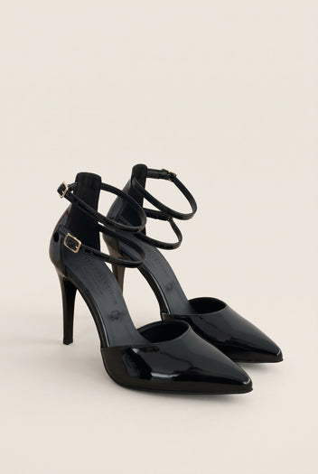 Black patent pointed toe pump with crossed ankle straps and buckle fastening in angled front view