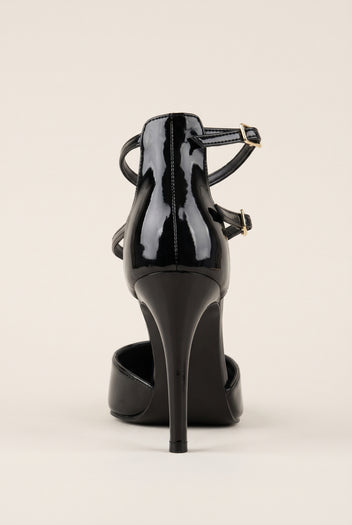 Black patent pump seen from behind with two thin straps wrapping the ankle and a tall slender heel